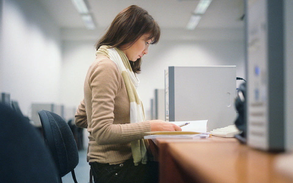 a woman studying for an English exam at her desk