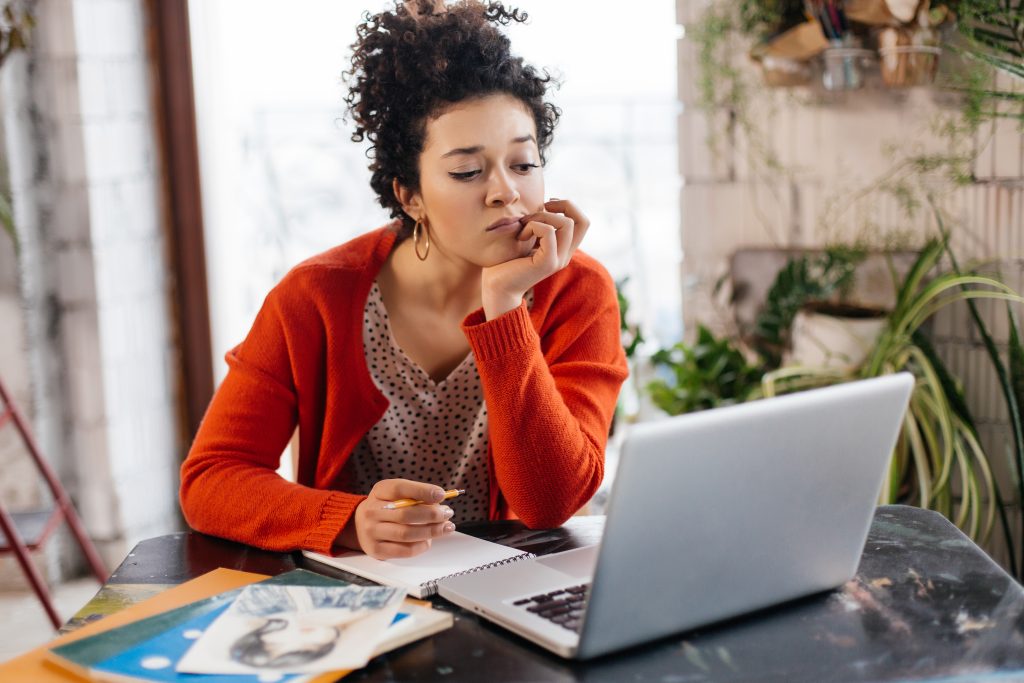 A woman sits at her desk looking at her desktop