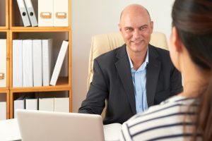 A consultant speaking with a client at his desk