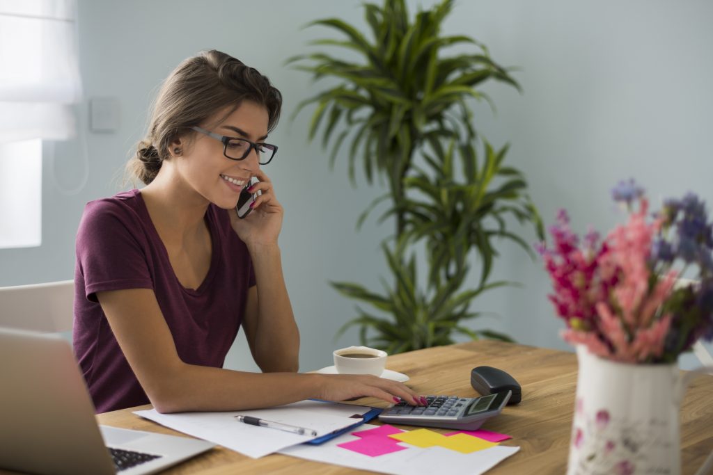 A bookkeeper files taxes as she's on a call with a client