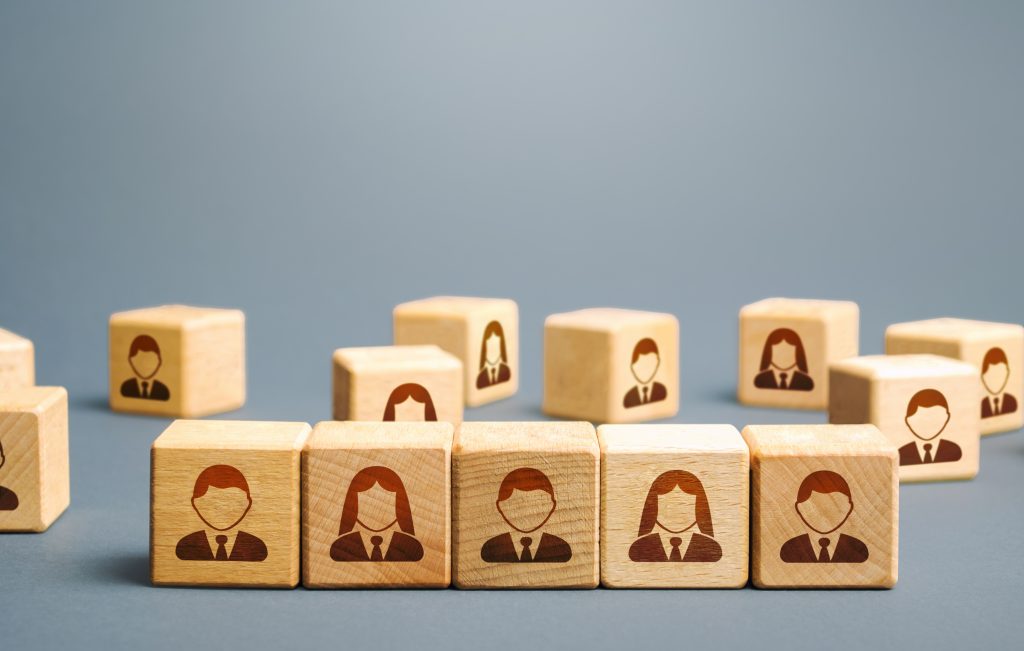 Wooden building blocks with professionals in suits printed on them
