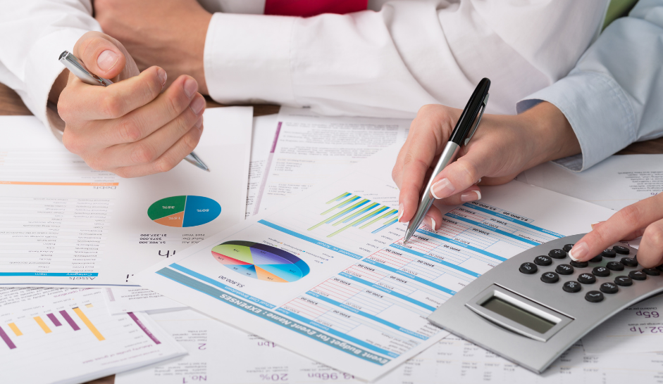 Accountants work on spreadsheets from a desk