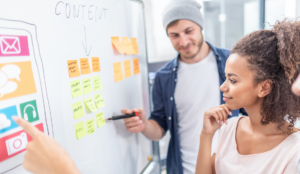 two people discussing digital marketing on a white board