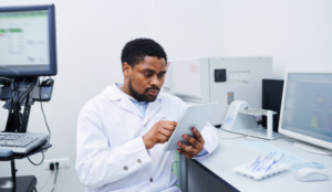 A healthcare professional looks at data on his notepad at his desk